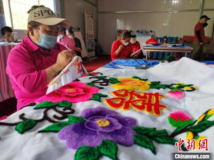 圖為婦女制作青繡?！?zhí)砀?攝